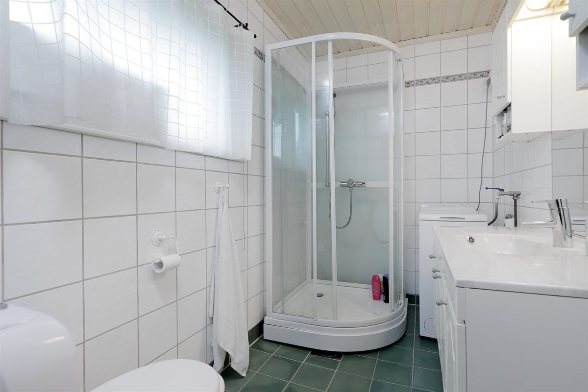 Badet i andre etasje er pent med lyse flissatte vegger og grønne gulvfliser med lun gulvvarme. Galleribilde