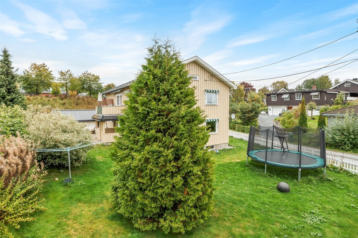 Solrik tomt som er pent opparbeidet med flotte plenareal som er trygt begrenset av et sjarmerende hvitmalt gjerde. Galleribilde