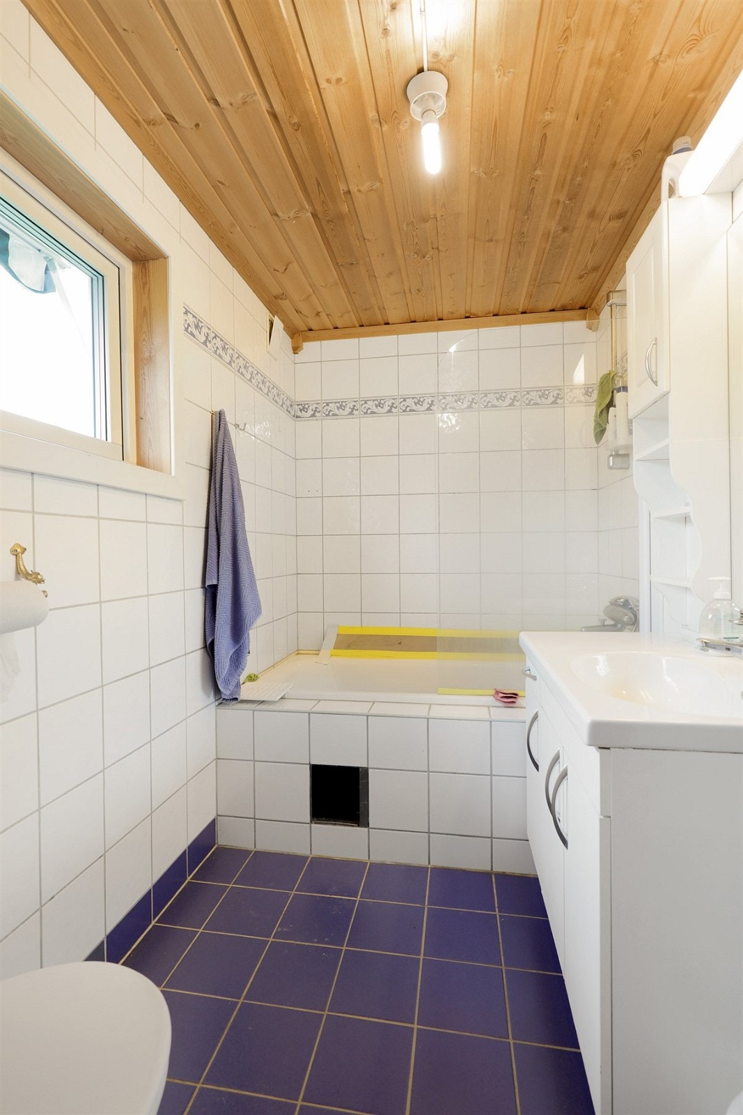 Badet i første etasje har blå gulvfliser med behagelig gulvvarme, lyse veggfliser og panelt himling. Galleribilde