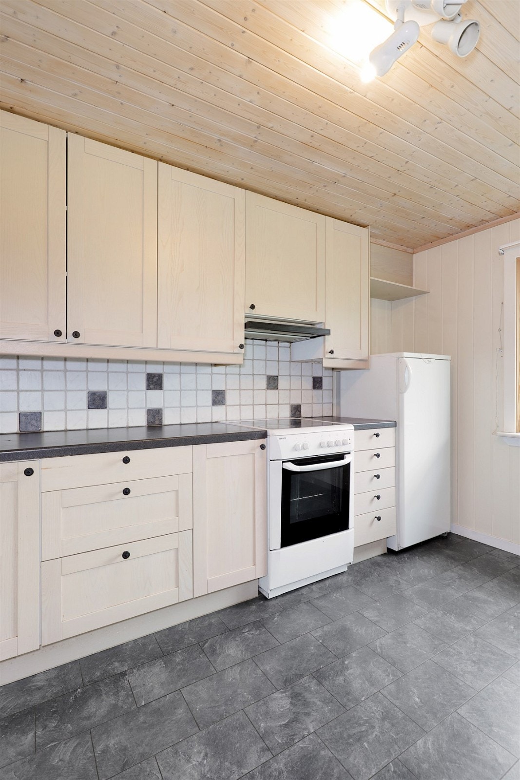 Den takhøye innredningen fra 2005 har lyse bjørkefronter og sort benkeplate med nedfelt oppvaskkum Galleribilde