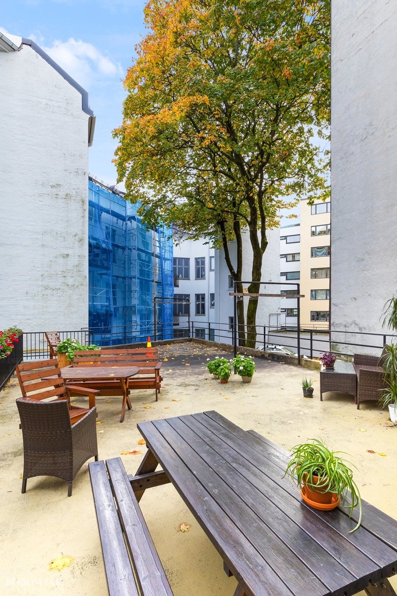 Hyggelig opparbeidet bakgård med beplantning og sittegrupper. Galleribilde