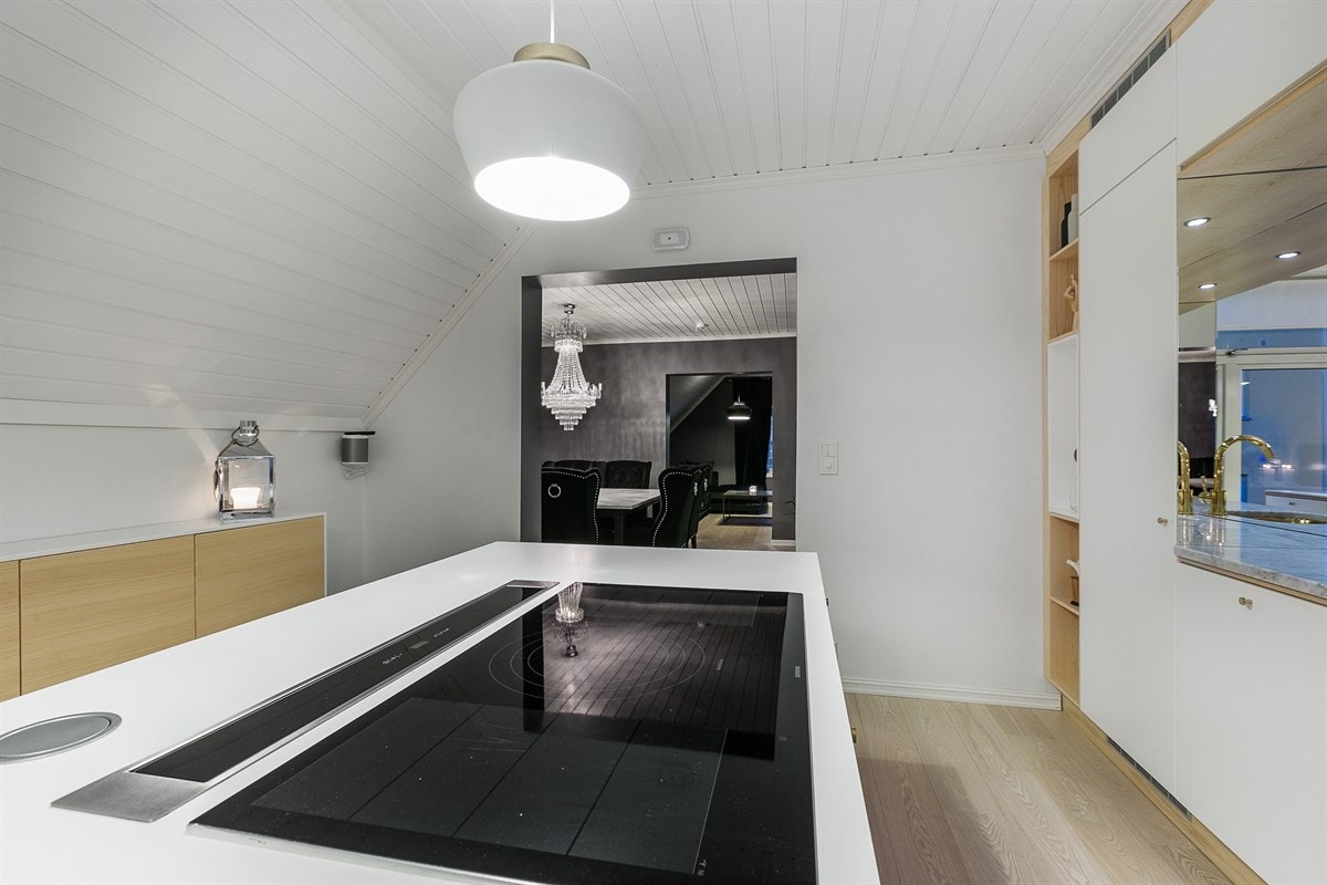 En ekstra bred induksjonstopp og ventilator er integrert i kjøkkenøyen som også har en smart barløsning for to. Galleribilde