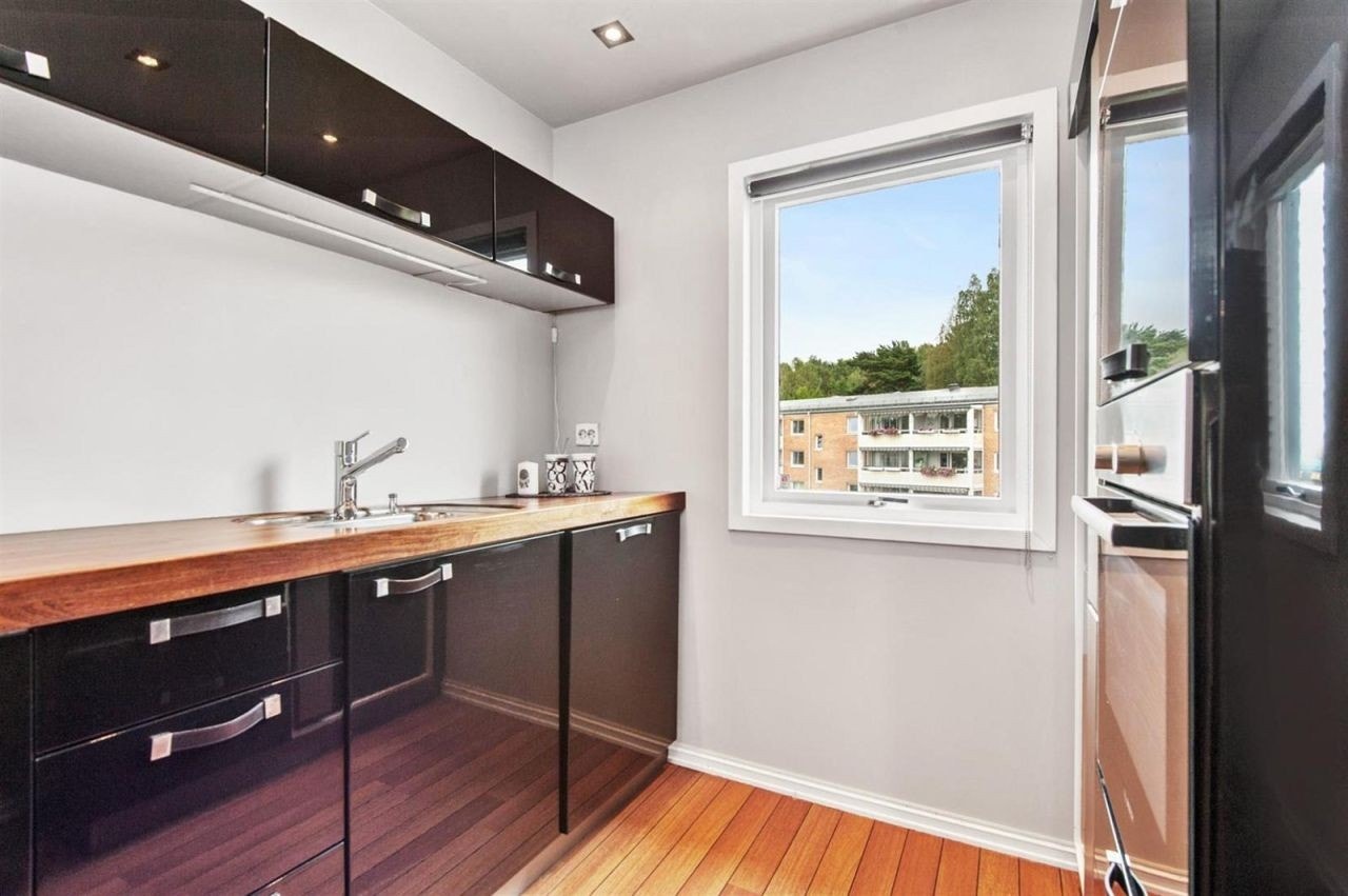 Kjøkken med kjøleskap, ovn, mikrobølgeovn, vannkoker, oppvaskmaskin og vindu. Galleribilde