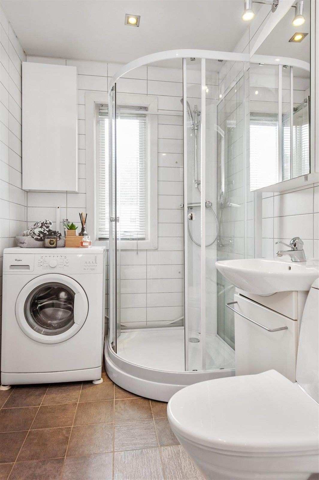 Bad med oppvaskmaskin, servant, underskap, veggskap, toalett og dusjkabinett. Downlights og LED-belysning på badet. Galleribilde