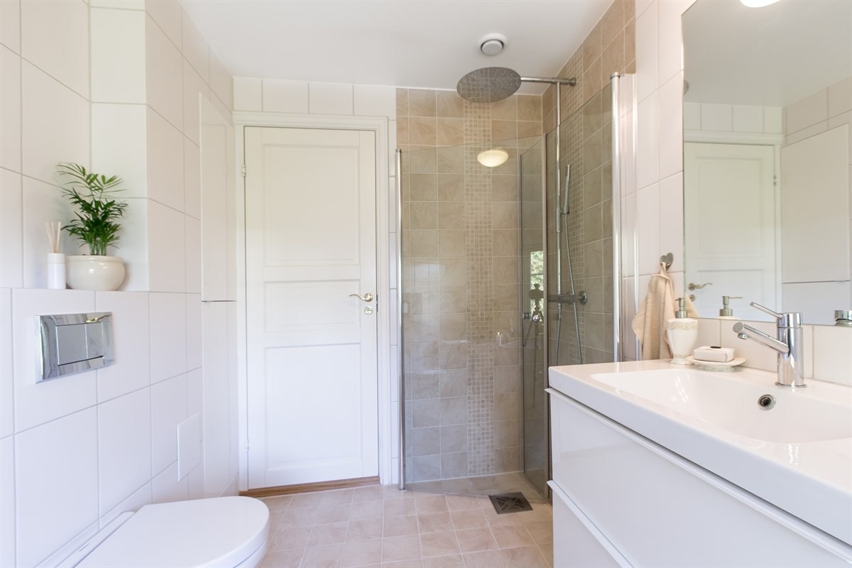 Badet har opplegg for vaskemaskin, flislagt gulv med varmekabler, fliser på vegger og malt himling. Galleribilde