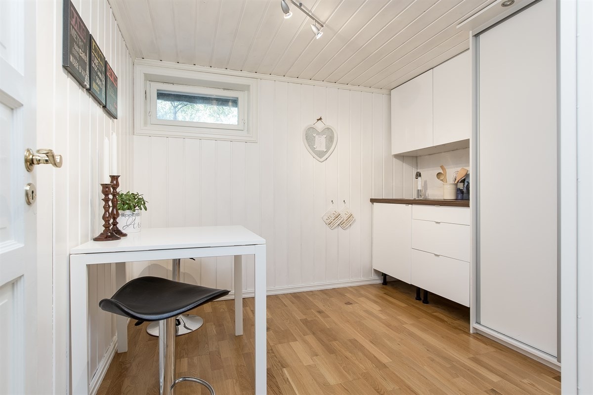 Kjøkken med spiseplass i u.etg. Kjøkkeninnredning med hvite høyglansede fronter, samt laminat benkeplate med skyllekum og ettgreps blandebatteri. Galleribilde