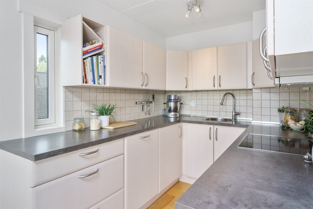 Kjøkken med lys innredning og hvitevarer. Opplegg for oppvaskmaskin Galleribilde