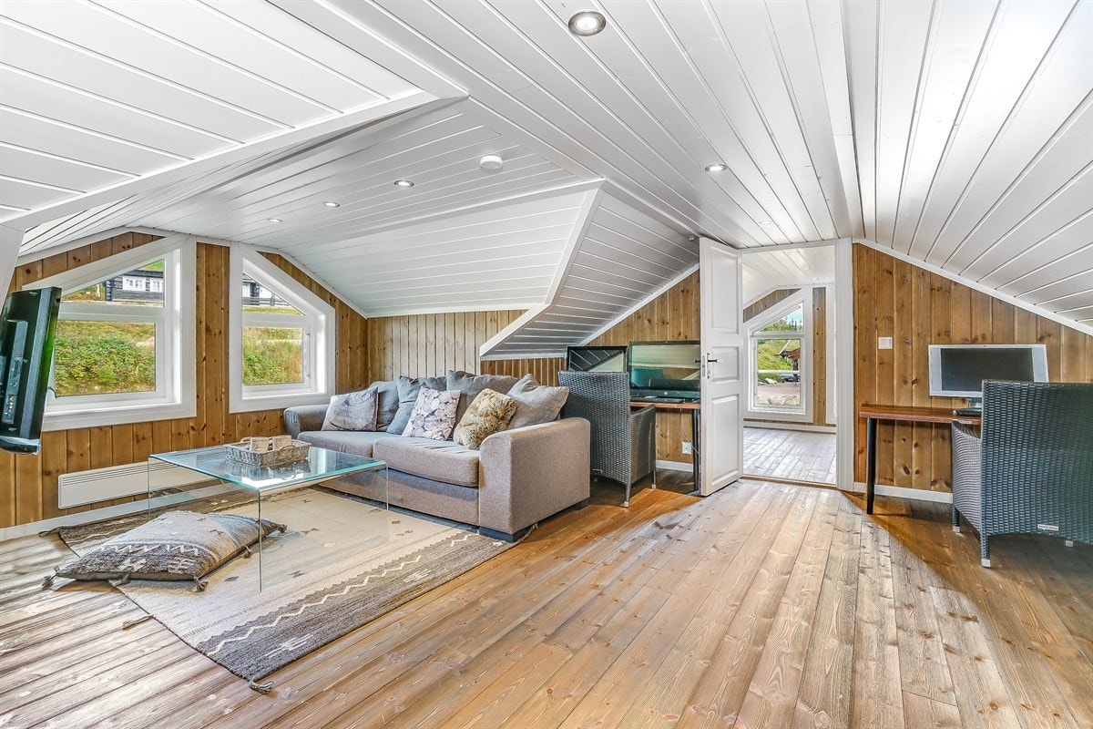 Rommet har beiset tregulv, beisede panelte vegger og lysmalt panelhimling med downlights Galleribilde