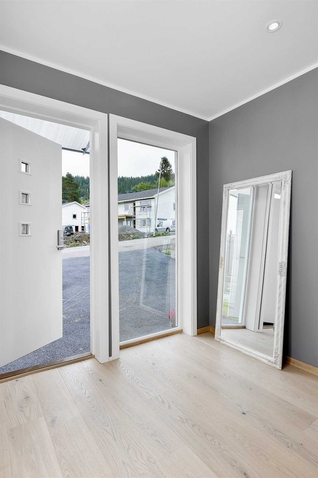 Boligen har adkomst via et pent inngangsparti med praktisk glassoverbygg, dør med innfelte glasspartier og et stort sidefelt i glass. Galleribilde