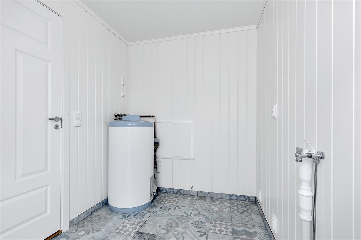 Vaskerommet har sluk i gulv, vaskekum, opplegg for vaskemaskin og tørketrommel, samt plass for noe oppbevaringsmøbel. Boligens varmtvannsbereder er også plassert her. Galleribilde