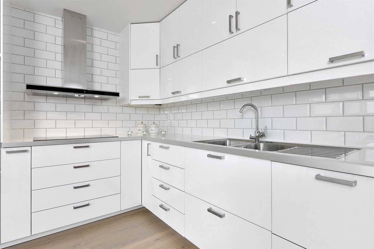 Innredningen har hvite høyglansfronter og laminert benkeplate med dobbel underlimt oppvaskkum. Galleribilde