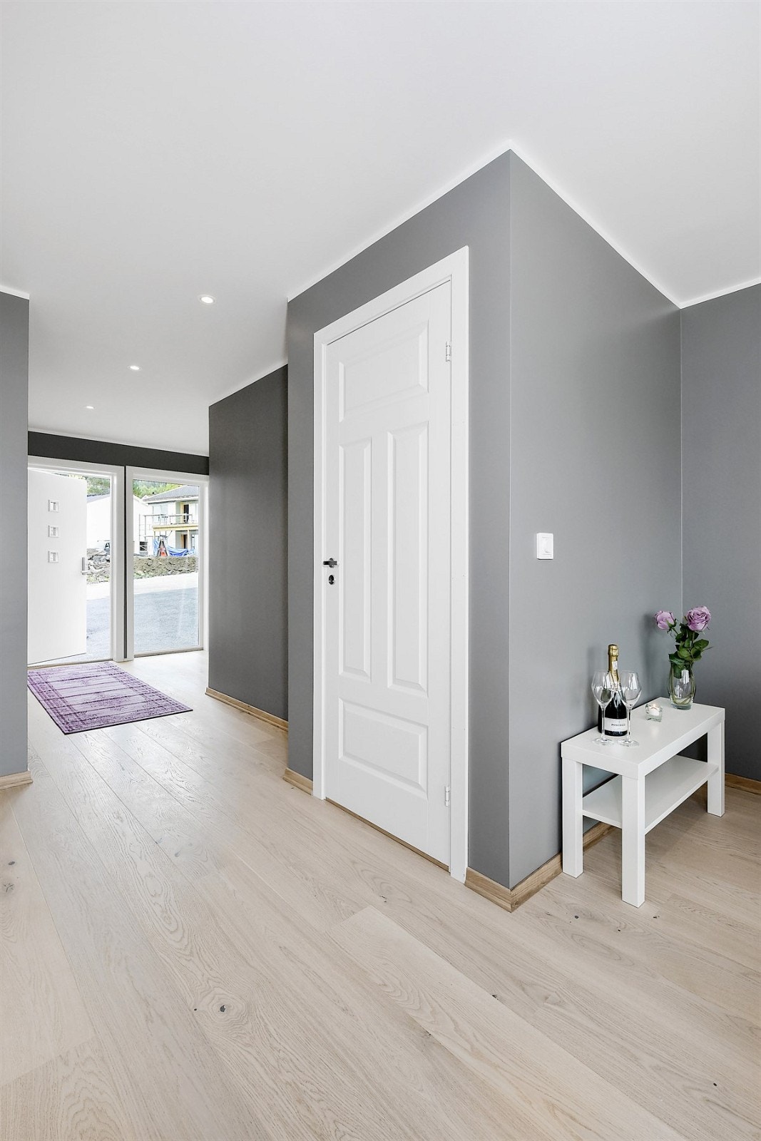 Entreen har parkett på gulv med gulvvarme, downlights og lyse veggflater, noe som gir et pent førsteinntrykk av boligen. Galleribilde