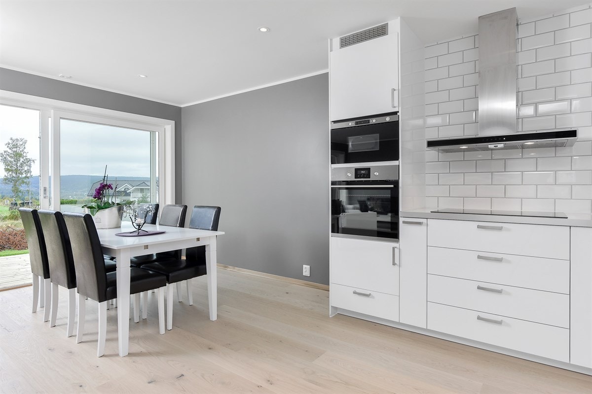 Stuen har store vindusflater fra gulv til tak langs hele endeveggen, noe som gir rikelig med naturlig lys. Galleribilde