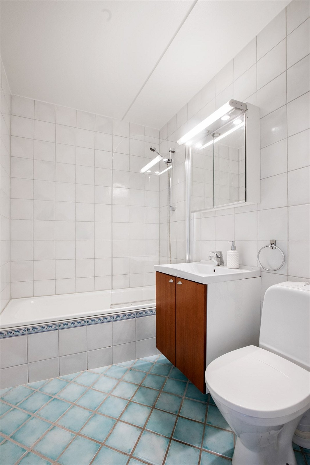 Baderommet har fliser på gulv. To klosett i leiligheten Galleribilde