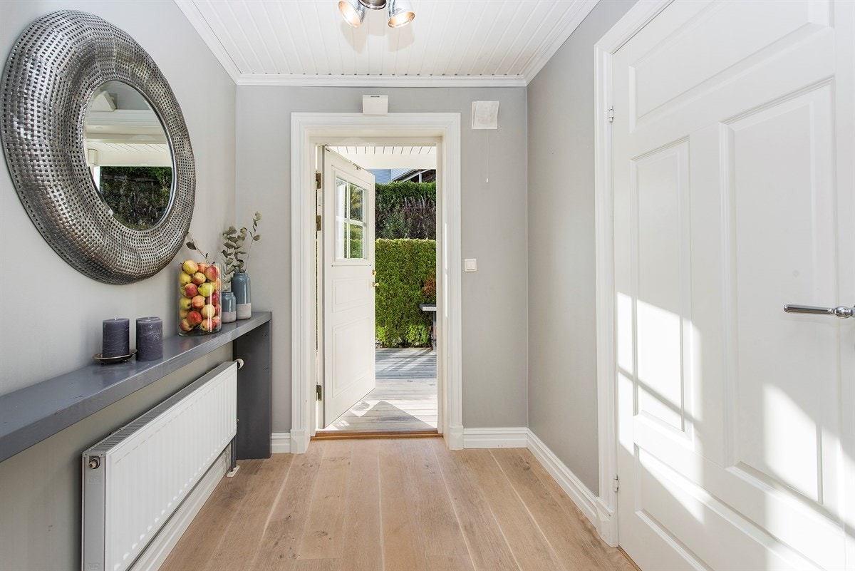 Koselig entre med parkett på gulv, spotlights i himling og lysinnslipp via glassfelt i inngangsdøren. Galleribilde