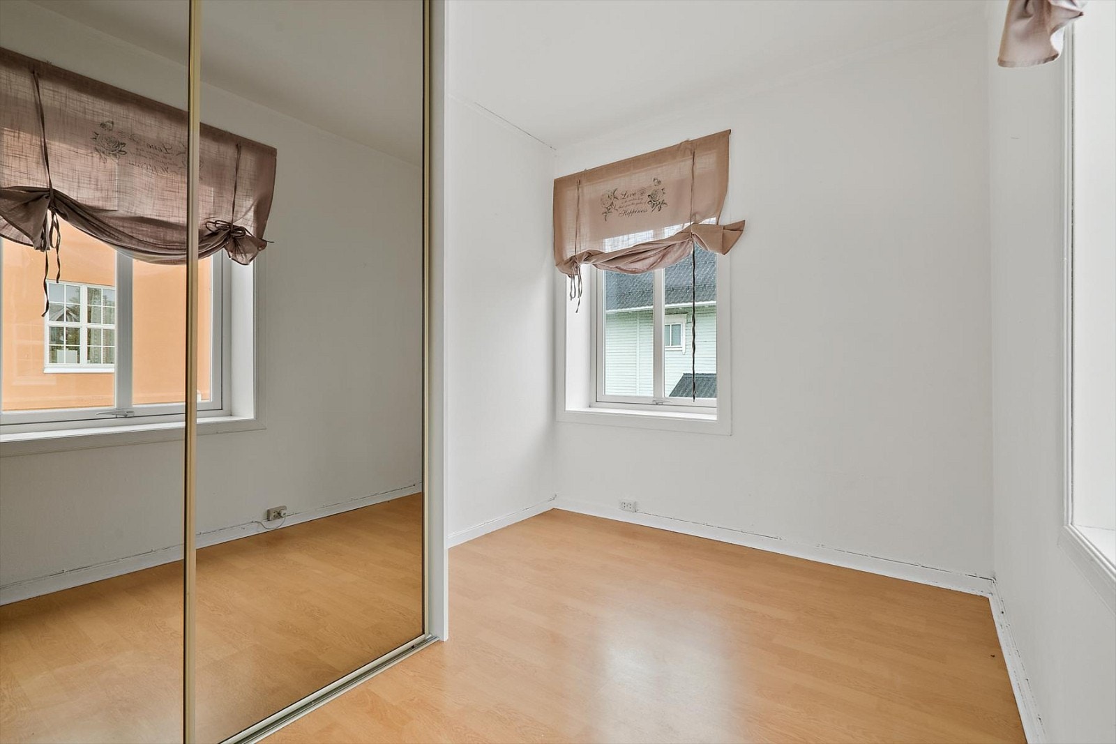 Hvitmalt soverom med to vinduer og skyvedørsgarderobe. Galleribilde