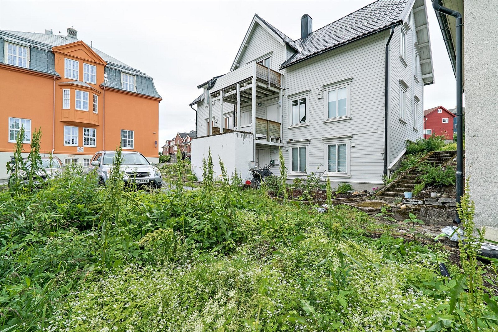 Utvendig parkering på nedsiden av boligen. Galleribilde