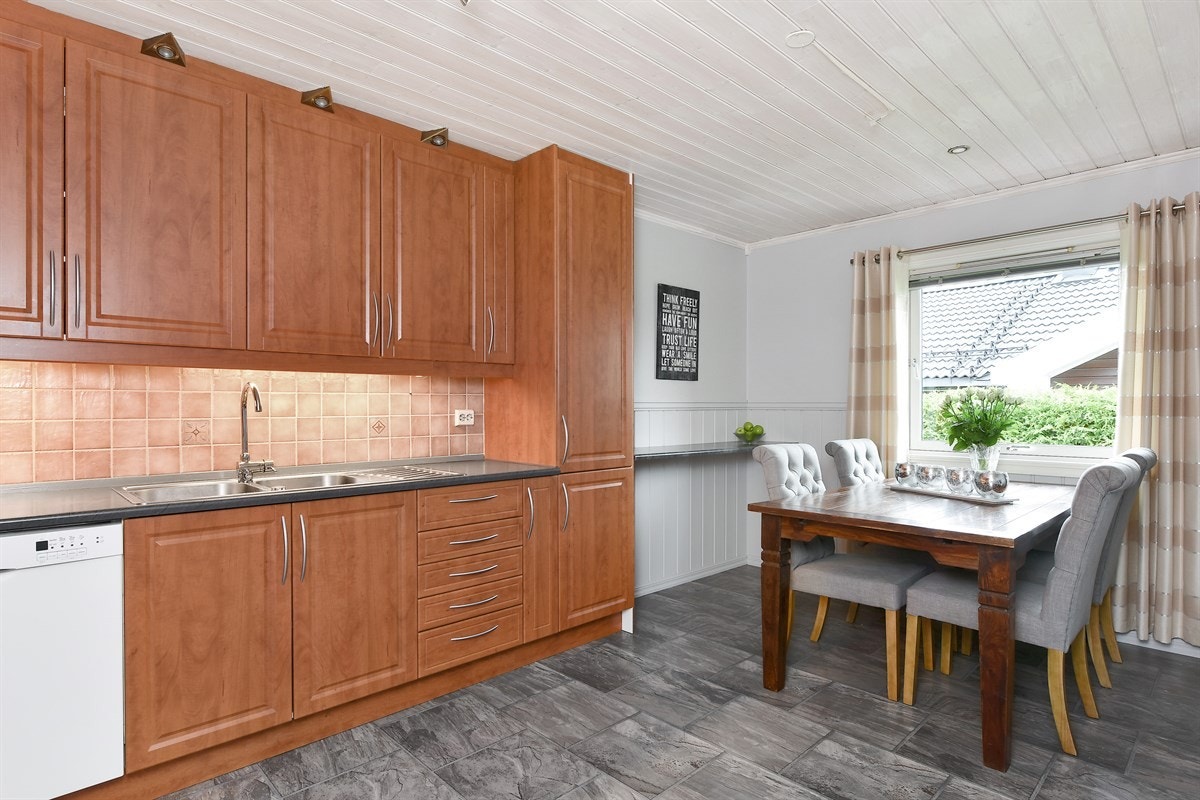 Det romslige kjøkkenet i første etasjen har laminat på gulv, fin plass for spisebord ved vinduet og er praktisk designet med god benke- og lagringsplass. Galleribilde