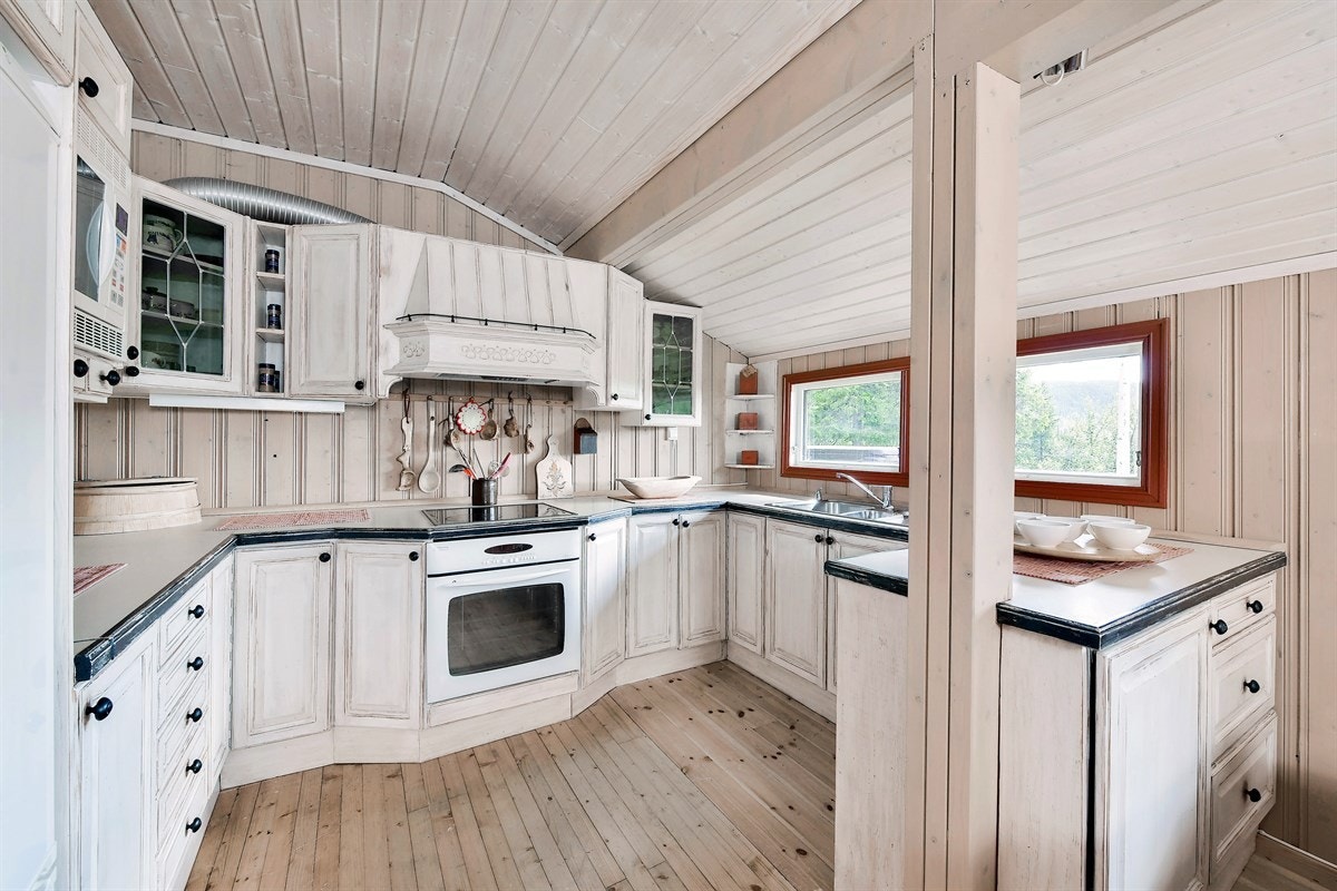 Kjøkkenet ligger i delvis åpen løsning med stuen og er holdt i en lys rustikk stil som kler hytta god. Galleribilde