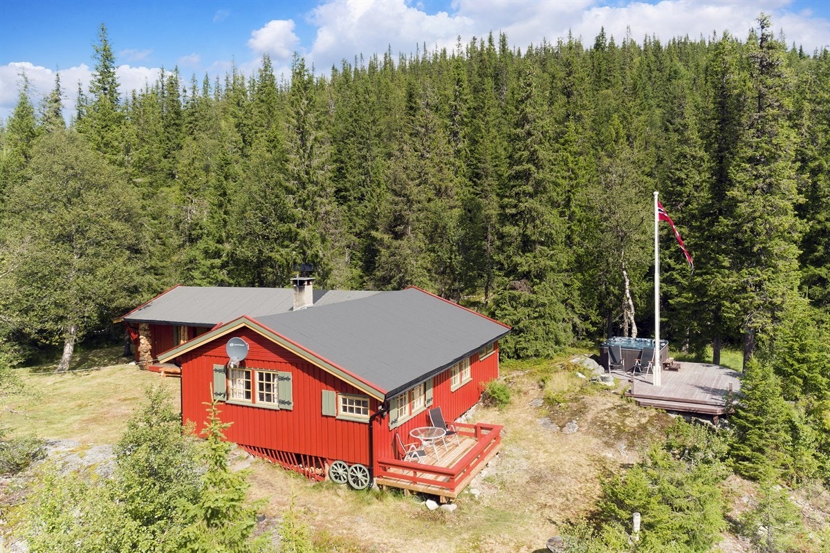 På sydsiden av hytta finner man en terrasse med rødmalt gjerde, nydelig utsikt over buktende skoglandskap og sol til ca. kl. 17. Galleribilde