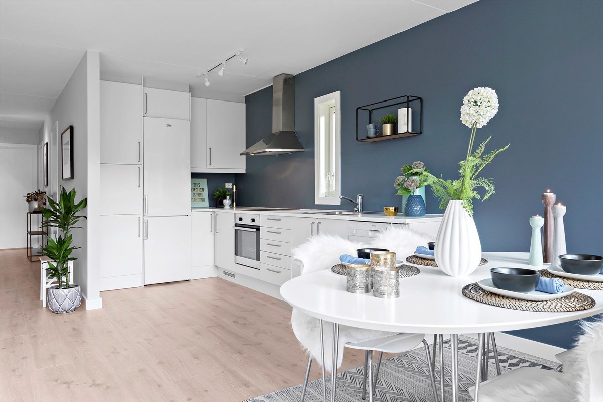 Godt vedlikeholdt kjøkken med hvit glatt kjøkkeninnredning og kontrastvegg i lekker farge Galleribilde