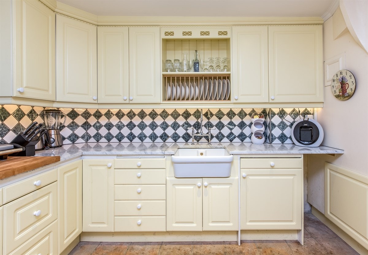 Her er det profilerte fronter og marmor benkeplate med keramikkvask. Galleribilde