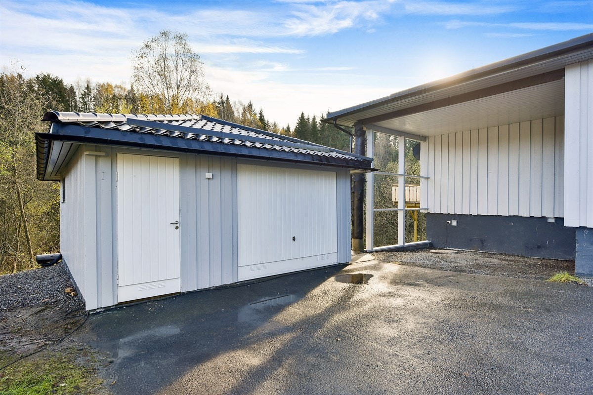 På den siden av boligen som ligger mot garasjen er det en gruslagt og overbygd uteplass som boligeier har benyttet som carport. Det er også plass for parkering av flere biler på asfaltert gårdsplass. Øvrig parkering etter områdets gjeldende bestemmelser. Galleribilde
