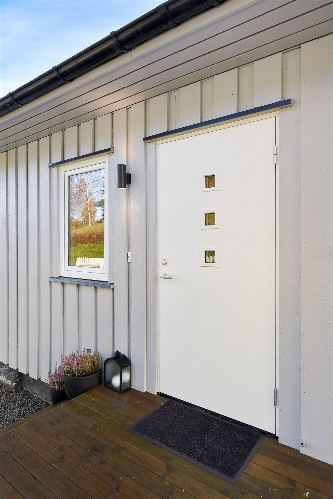 Inngangspartiet er pent og ligger tilknyttet terrassen med et lite takoverbygg og inngangsdør med innfelte glasspartier. Galleribilde