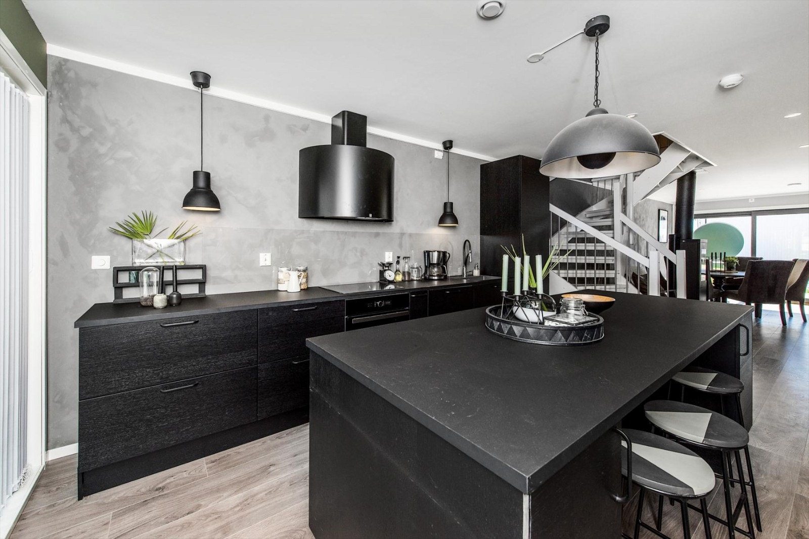 Kjøkkeninnredning med kjøkkenøy i mørk finert utførelse og laminat benkeplate med rett kant. Galleribilde