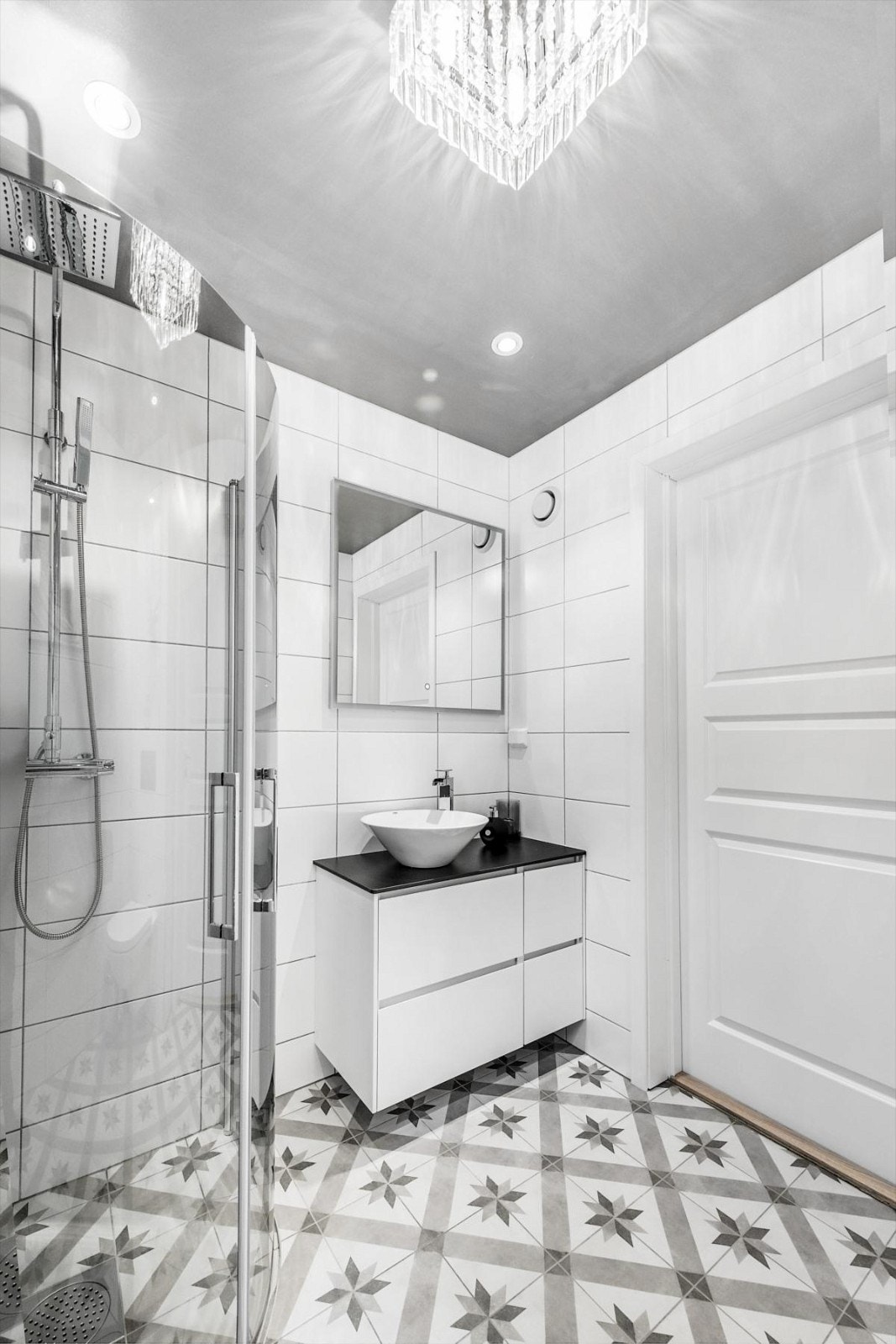 Dusjhjørne med innfellbare glassvegger, dusjarmatur på vegg med armatur med ett greps blandebatteri, servantinnredning og ett greps blandebatteri. Galleribilde