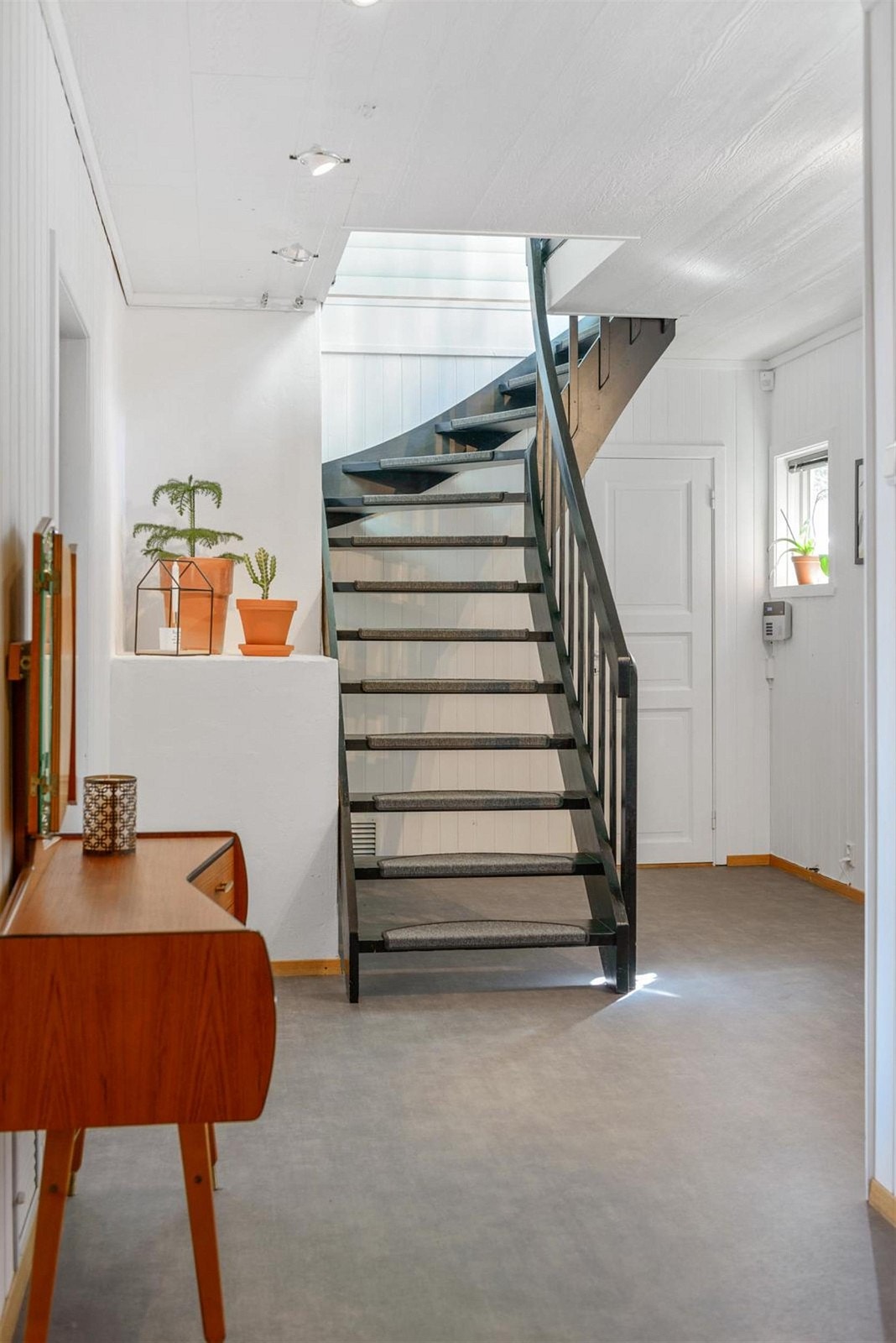 Ved siden av trappen er det inngang til et oppbevaringsrom som nyttes til klesrom for barnefamilien som bor her, og videre kommer en inn til vaskerommet. Galleribilde