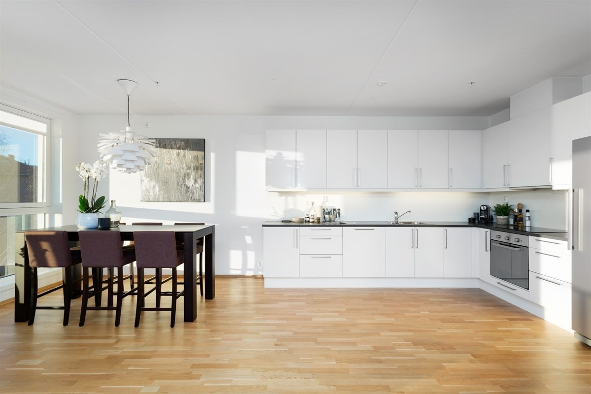 Innredningen er fra HTH, og har hvite slette fronter med laminert benkeplate og nedfelt oppvaskkum i stål Galleribilde