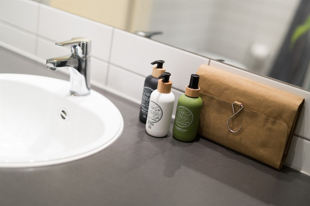 Innredningen består av en moderne skapseksjon med benkeplate og servant, samt et stort speil Galleribilde