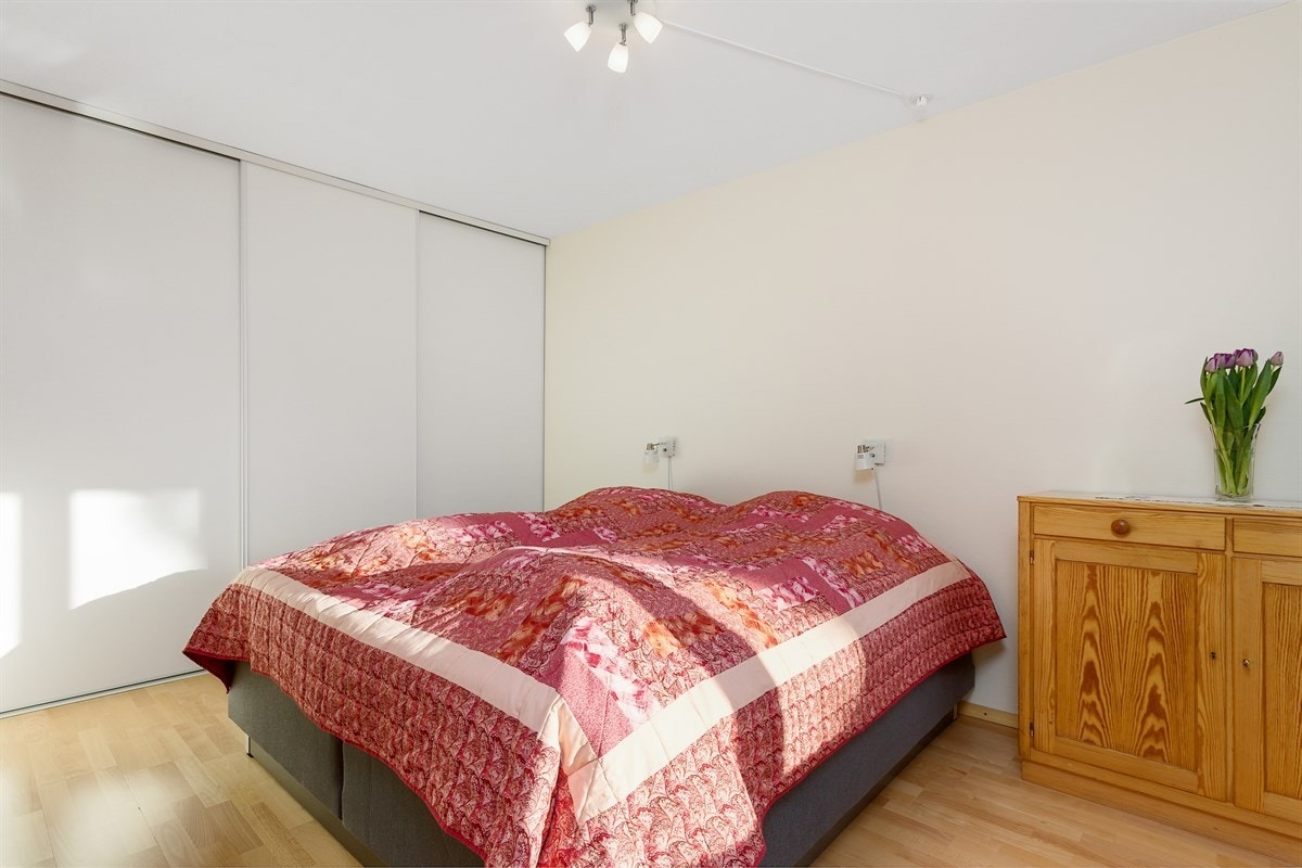 Stor, takhøy skyvedørsgarderobe på hovedsoverom Galleribilde