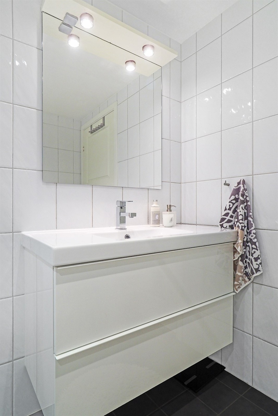 Proaktiv Eiendomsmegling - Badet er innredet med vegghengt toalett, vask med underskap og dusjnisje Galleribilde