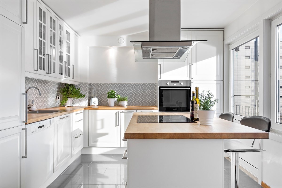 Kjøkkenet er lekkert og velutstyrt, samt praktisk designet med takhøye skap og god skap- og benkeplass Galleribilde