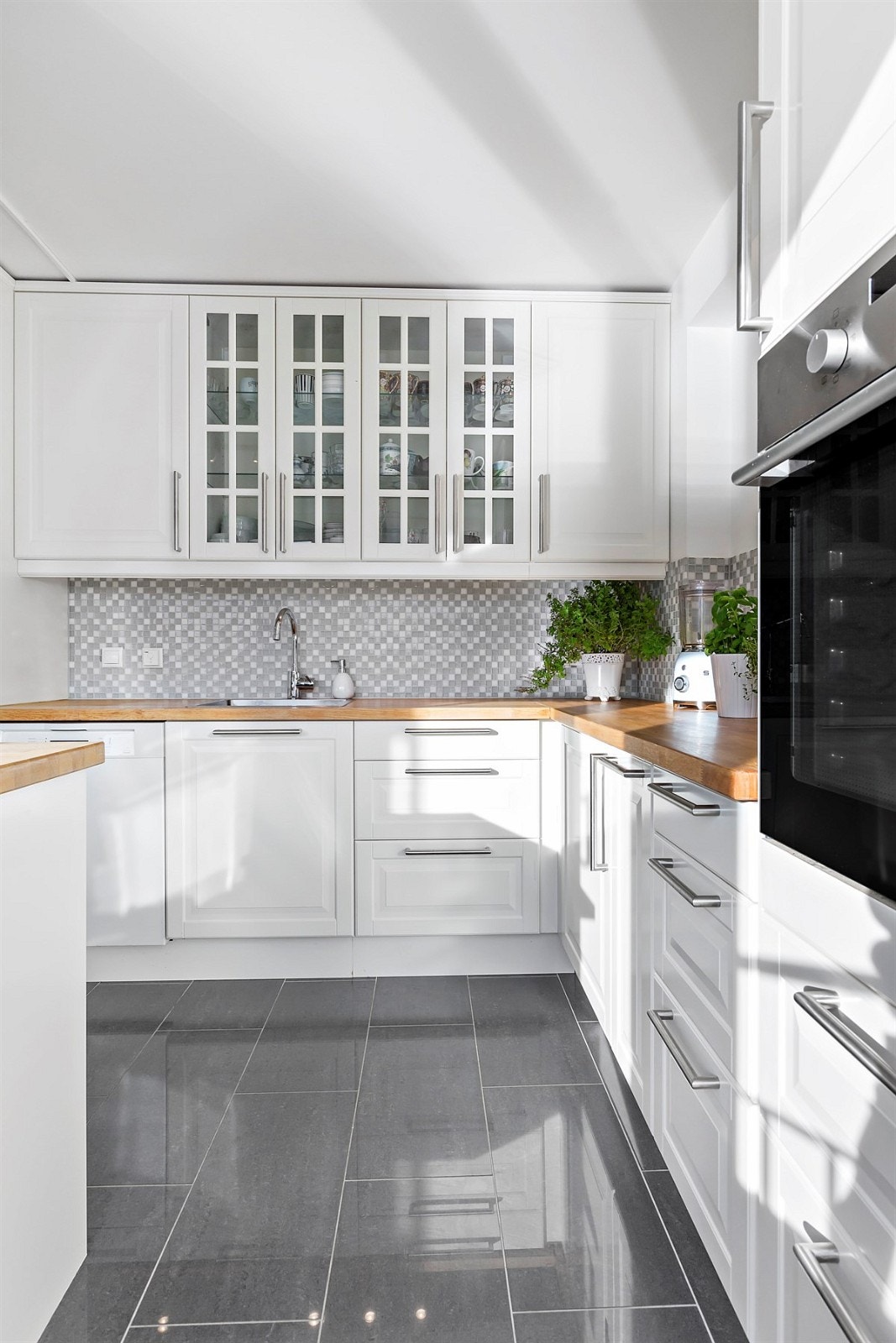 Kjøkkenet har integrert kombinert kjøl/frys, stekeovn og oppvaskmaskin, samt en stilig kjøkken-øy med induksjonstopp og hetteventilator Galleribilde