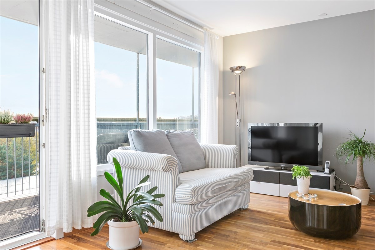 Leiligheten har en innbydende stue med god plass for sofaløsning med tilhørende møblement og spisebord Galleribilde