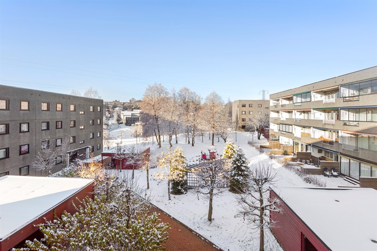 Hyggelig utsikt fra balkong mot parkmessige fellesareal med sittegrupper, lekeplasser mv. Galleribilde