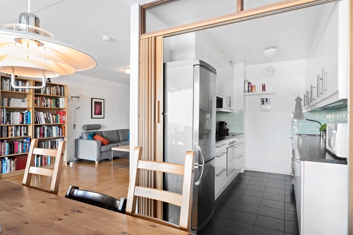 Smart løsning med plassbesparende skyvedør mellom spisestue og kjøkken. Galleribilde