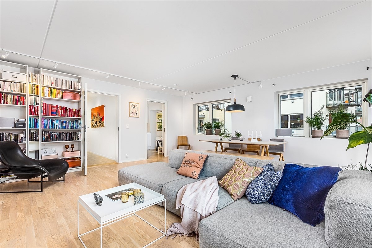 Det er lagt 3-stavs eikeparkett på gulvet og veggene er holdt i skinnende hvitt. Her er det god plass for sofaløsning med tilhørende møblement og langbord. Galleribilde