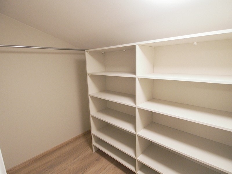 Walk-in garderobe med innebygde hyller til klær og sko. Stativ til å oppheng. Galleribilde