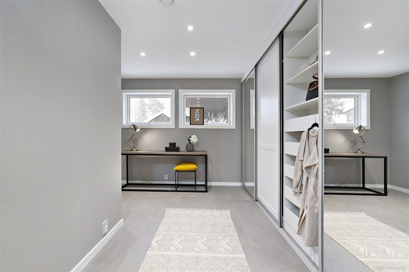 Fliselagt omkledningsrom med stor skyvedørsgarderobe og egen inngang. Galleribilde