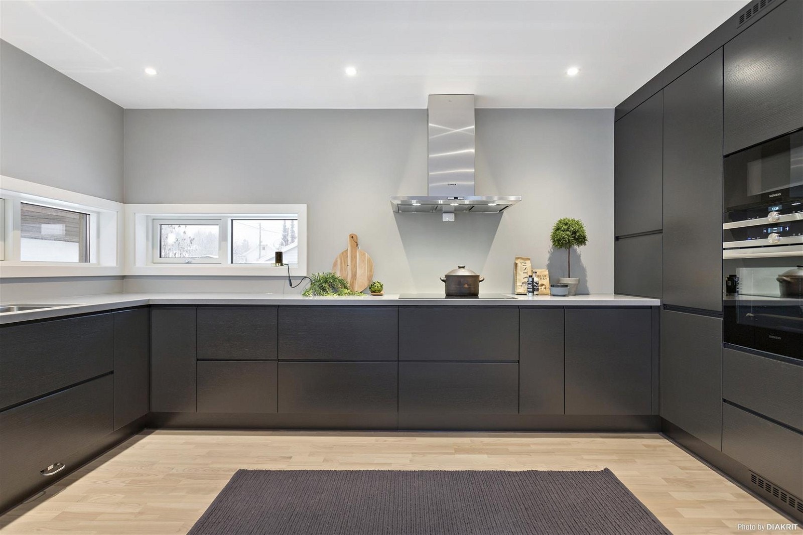 Kjøkken med moderne svarte fronter og lys Durastone benkeplate Galleribilde