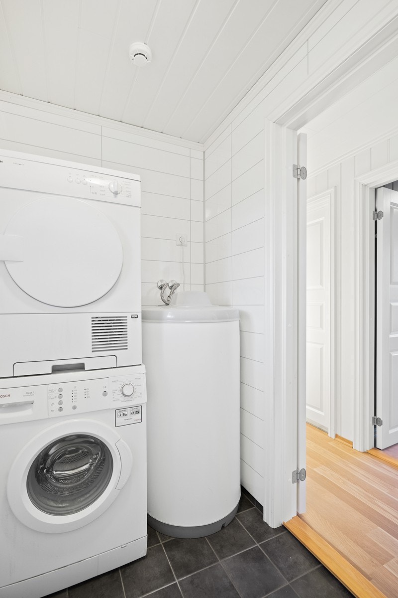 God plasst til vaskemaskin og tørketrommel på vaskerom Galleribilde