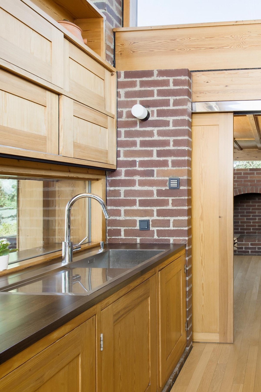 Planlimt stål oppvaskkum i mørk eik benkeplate. Legg merke til de flotte skyvedørene i tre! Galleribilde