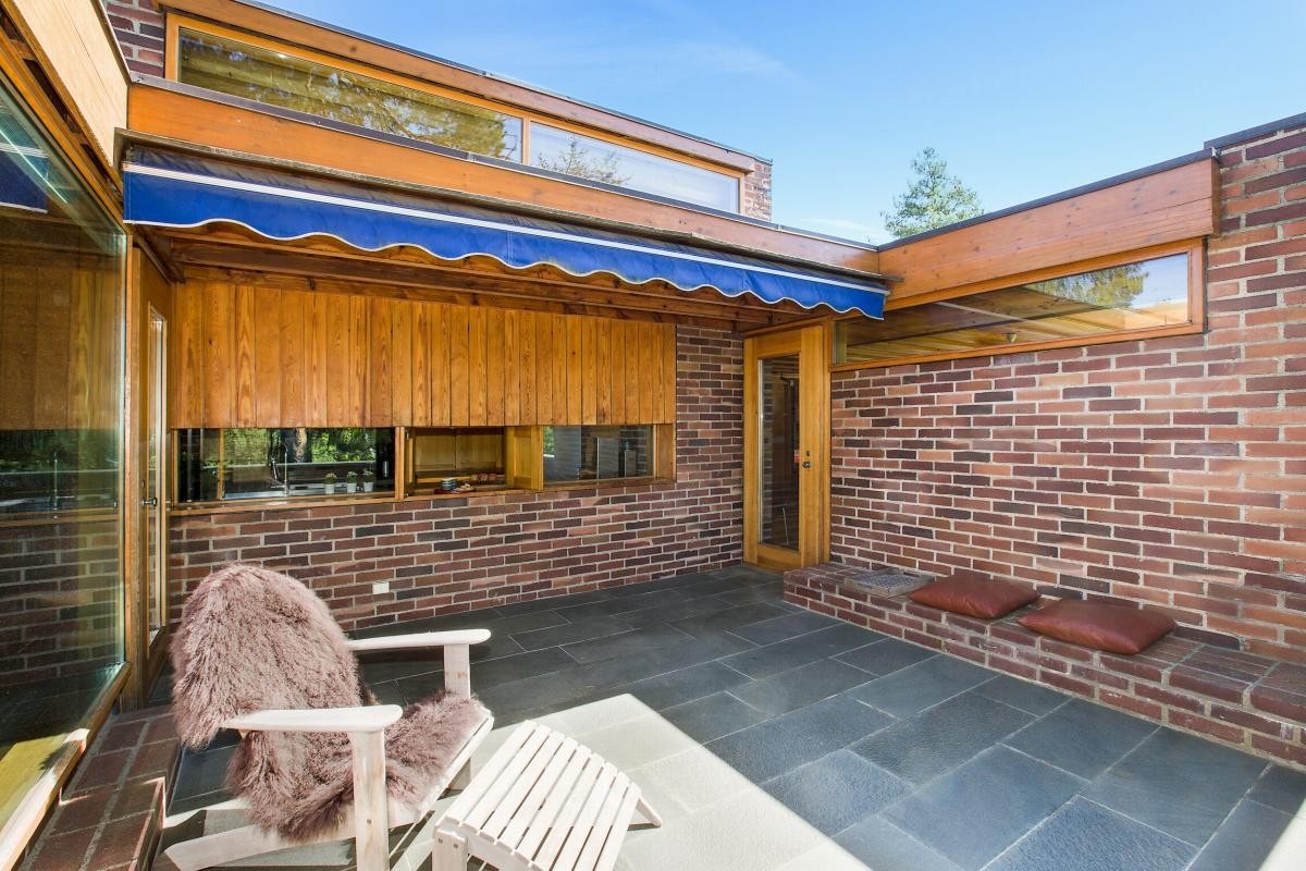 Atriumterrasse med inngang til spisestue på den ene siden og stuen på den andre siden Galleribilde