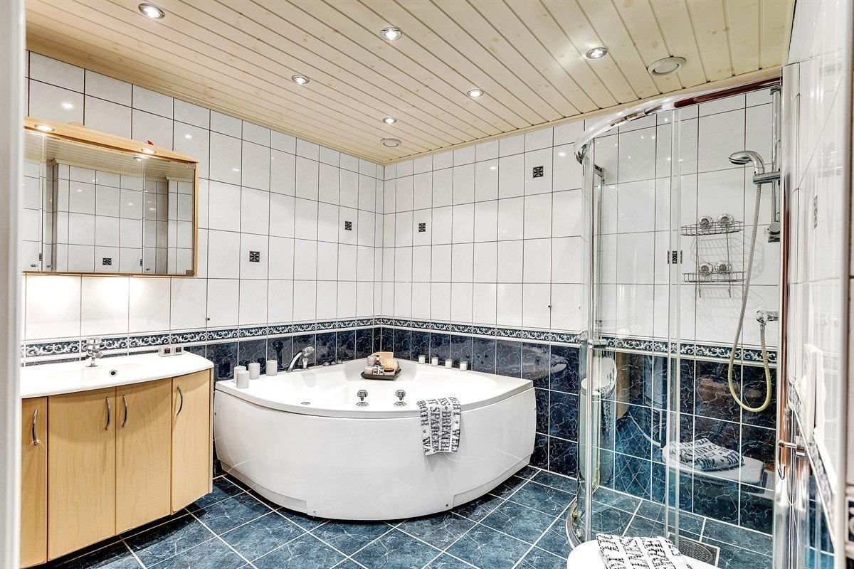 Baderommet har boblebadekar, et dusjhjørne med skyvedører i glass, samt et vegghengt toalett. Galleribilde