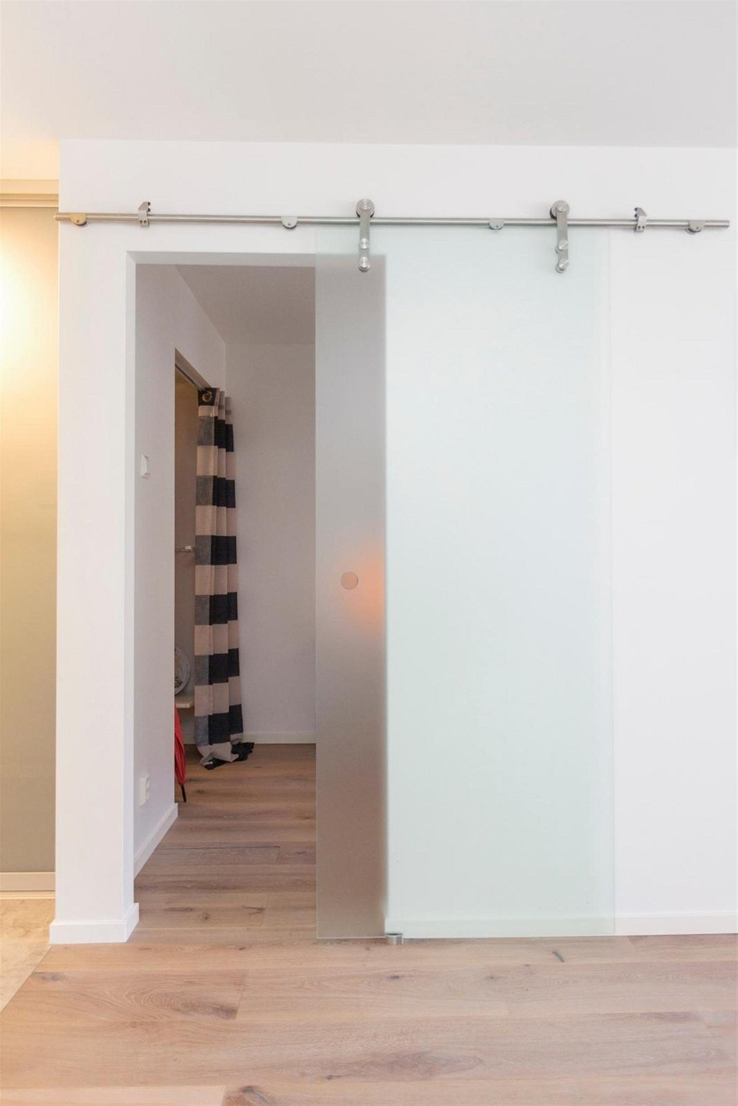 Skyvedør i frostet glass skiller soverommet fra stuen Galleribilde