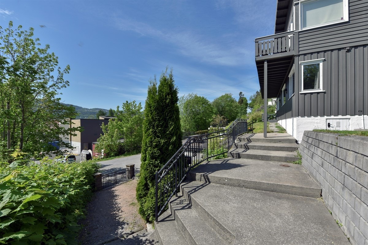 Tomten er velstelt og vakkert opparbeidet med åpent plenareal, trapper, pyntelige forstøtningsmurer, gjerder og stilig smijernsrekkverk. Galleribilde